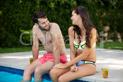 Young couple interacting with each other at poolside