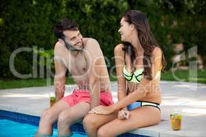 Young couple interacting with each other at poolside