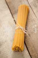 Bundle of raw spaghetti tied with white ribbon