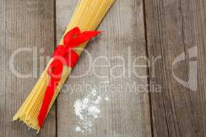 Bundle of raw spaghetti and flour