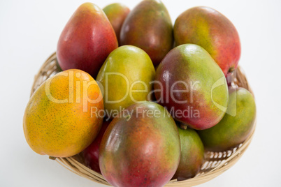 Close-up of red mangoes in wicker basket