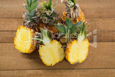 Halved pineapples on wooden table