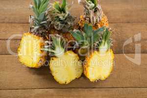 Halved pineapples on wooden table