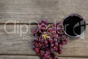 Overhead of red bunch of grapes with glass of red wine