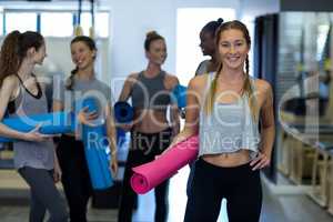 Portrait of beautiful woman holding yoga mat