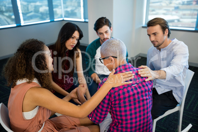 Creative business team consoling upset colleague