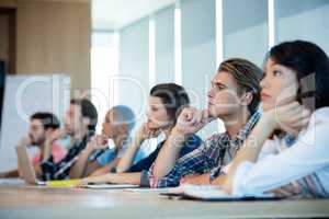 Creative business team listening at meeting in conference room