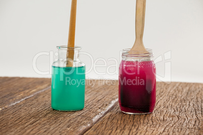 Paint brushes with blue and red paint dipped into water