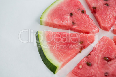 Slices of watermelon arranged on white background