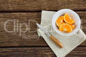 Slices of oranges in bowl on wooden table
