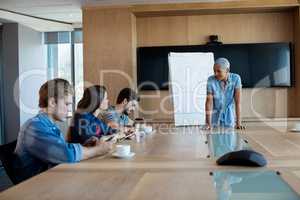 Woman giving presentation to her colleagues in conference room