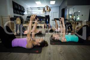 Group of fit women exercising with pilates ring