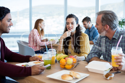 Creative business team discussing while having meal