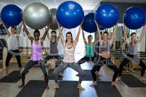 Portrait of smiling women exercising with fitness ball