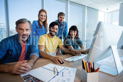 Creative business team working together on desktop pc in office