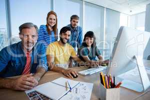 Creative business team working together on desktop pc in office