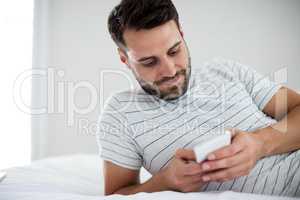 Man using mobile phone on bed