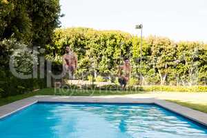 Young couple jumping together in the pool