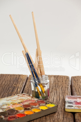 Paint brush in a jar filled with water and watercolors