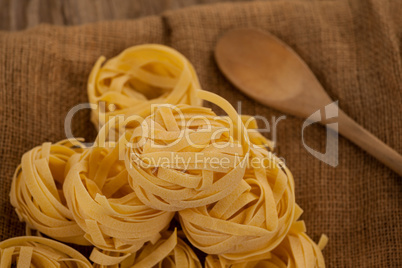 Fettuccine pasta and wooden spoon on sack