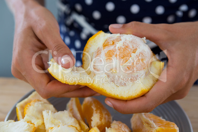 Woman peeling orange