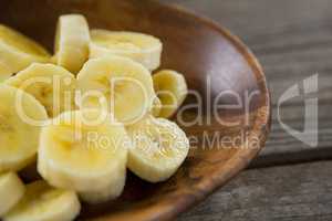 Slices of banana in plate on wooden table