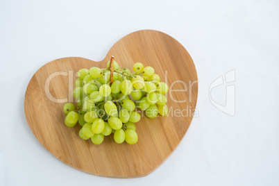 Overhead of green bunch of grapes on chopping board