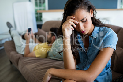 Couple ignoring each other in living room