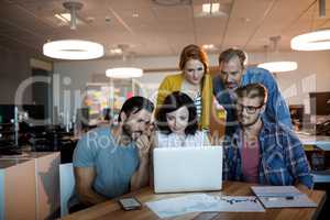 Creative business team discussing over the laptop