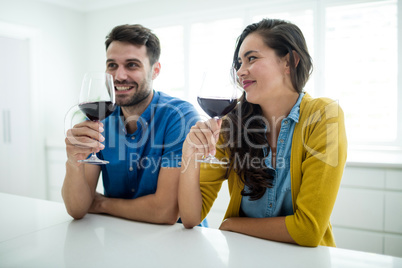 Couple having red wine in the kitchen