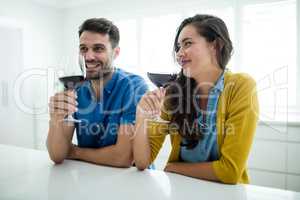 Couple having red wine in the kitchen