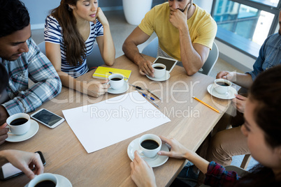 Creative business team having meeting over coffee in meeting room