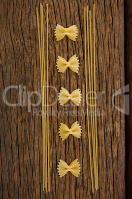 Farfalle and spaghetti on wooden surface