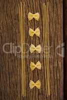 Farfalle and spaghetti on wooden surface