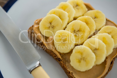 Sliced bananas spread on brown bread in plate