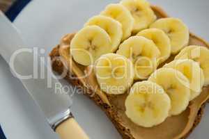 Sliced bananas spread on brown bread in plate
