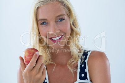 Portrait of beautiful woman holding red apple