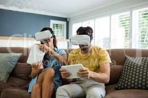 Couple using virtual reality headset in living room