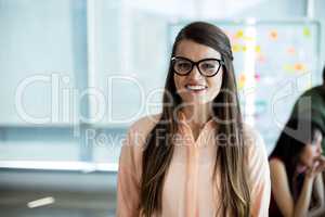 Woman in spectacles smiling in office