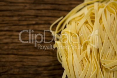 Raw tagliatelle pasta on wooden surface