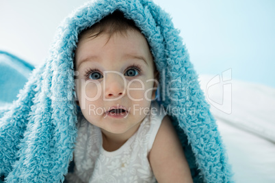 Cute baby girl under the blanket on bed