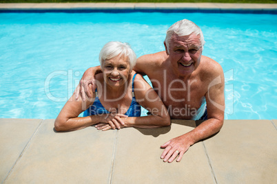 Portrait of senior couple relaxing together in pool