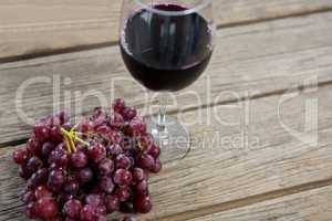 Close-up of red bunch of grapes with glass of red wine