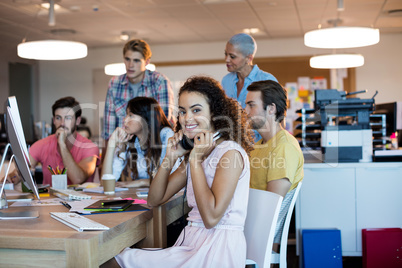 Woman with headphones working with her team in office