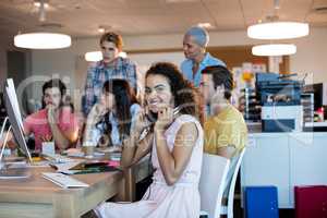 Woman with headphones working with her team in office