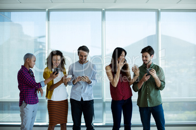 Creative business team interacting while using mobile phone