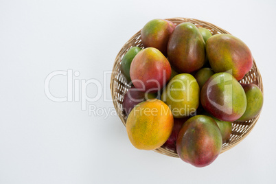 Overhead of red mangoes in wicker basket