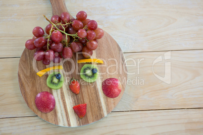 Close-up of various fruits on chopping board on wooden table