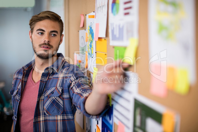 Man touching sticky note on the board