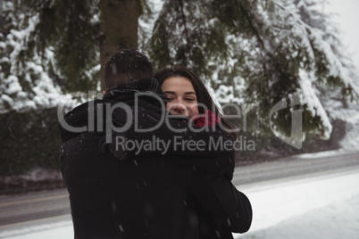Couple embracing in forest during winter